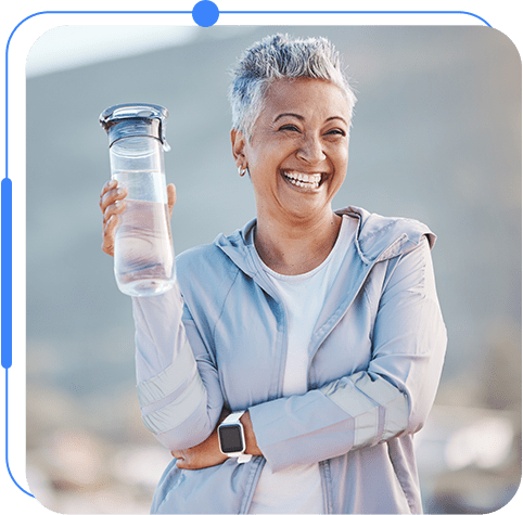 A woman holding onto a water bottle and smiling.